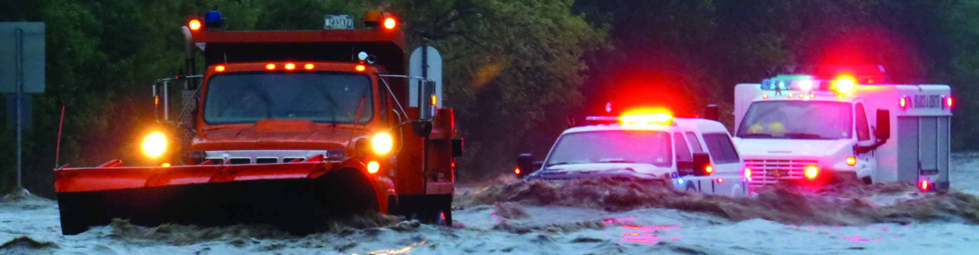 Emergency vehicles driving through floodwaters