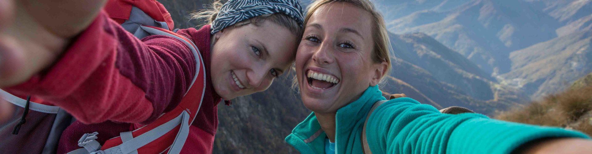 two happy women taking a selfie on a hike