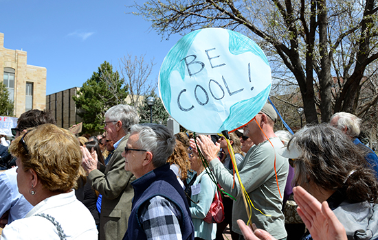 Local resident holds sign that says, "Be Cool!"