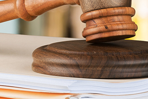 Cropped image of a gavel on top of a folder of papers