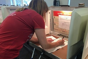 Voter filling out her ballot at a voting booth