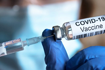 Photo of a syringe being filled from a vile of COVID-19 vaccine